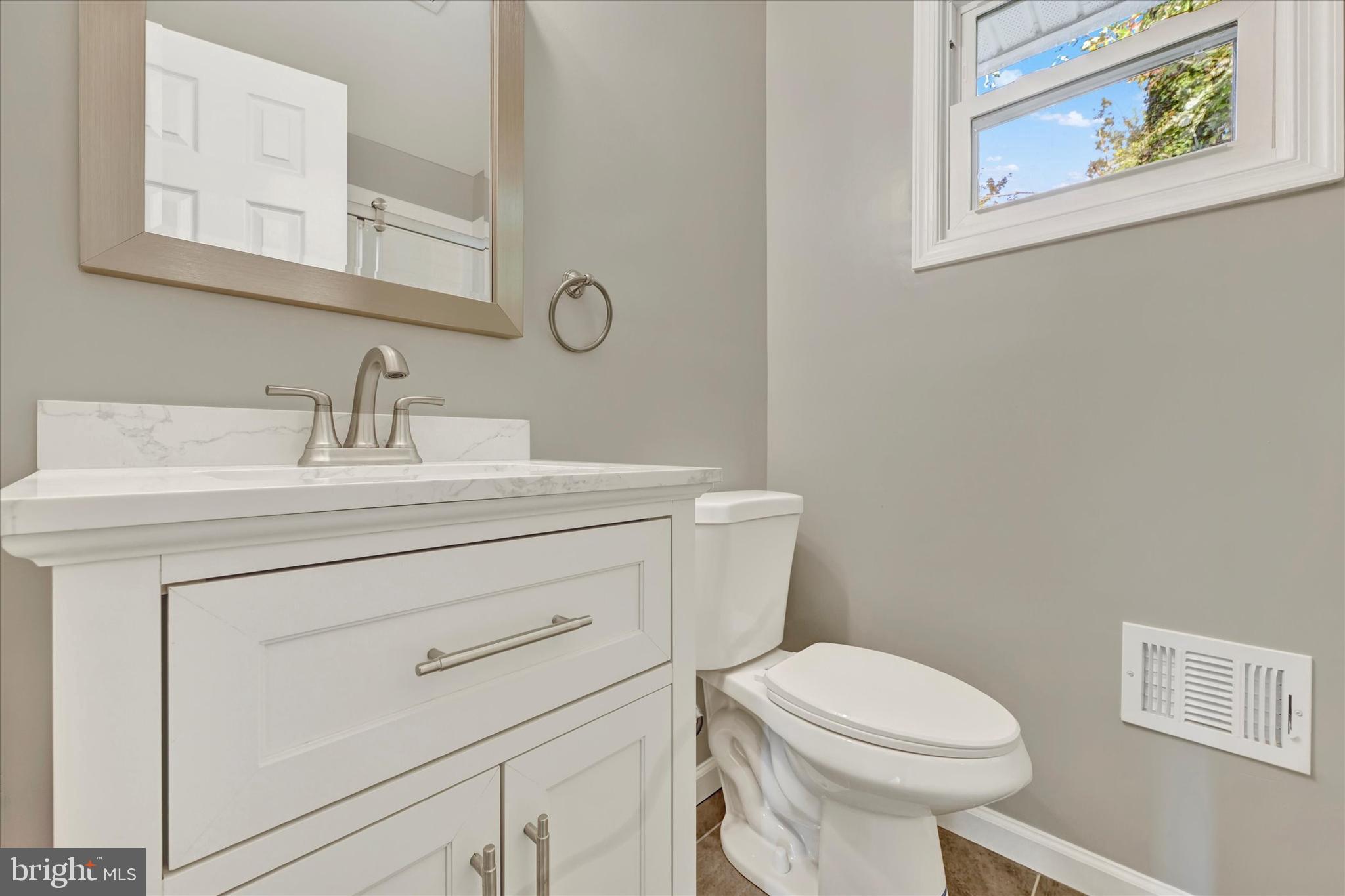 12106 Bluhill Road Silver Spring, MD 20902 - Photo 13 of 16 a bathroom with a toilet sink vanity and mirror