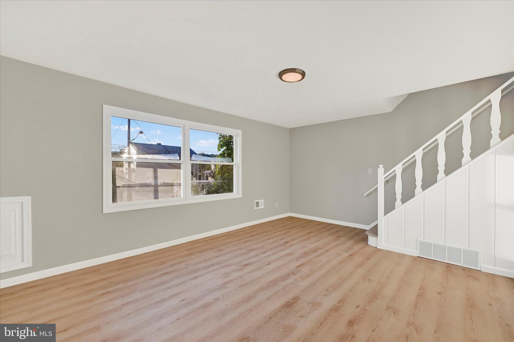 12106 Bluhill Road Silver Spring, MD 20902 - Photo 2 of 16 a view of an empty room with wooden floor and a window