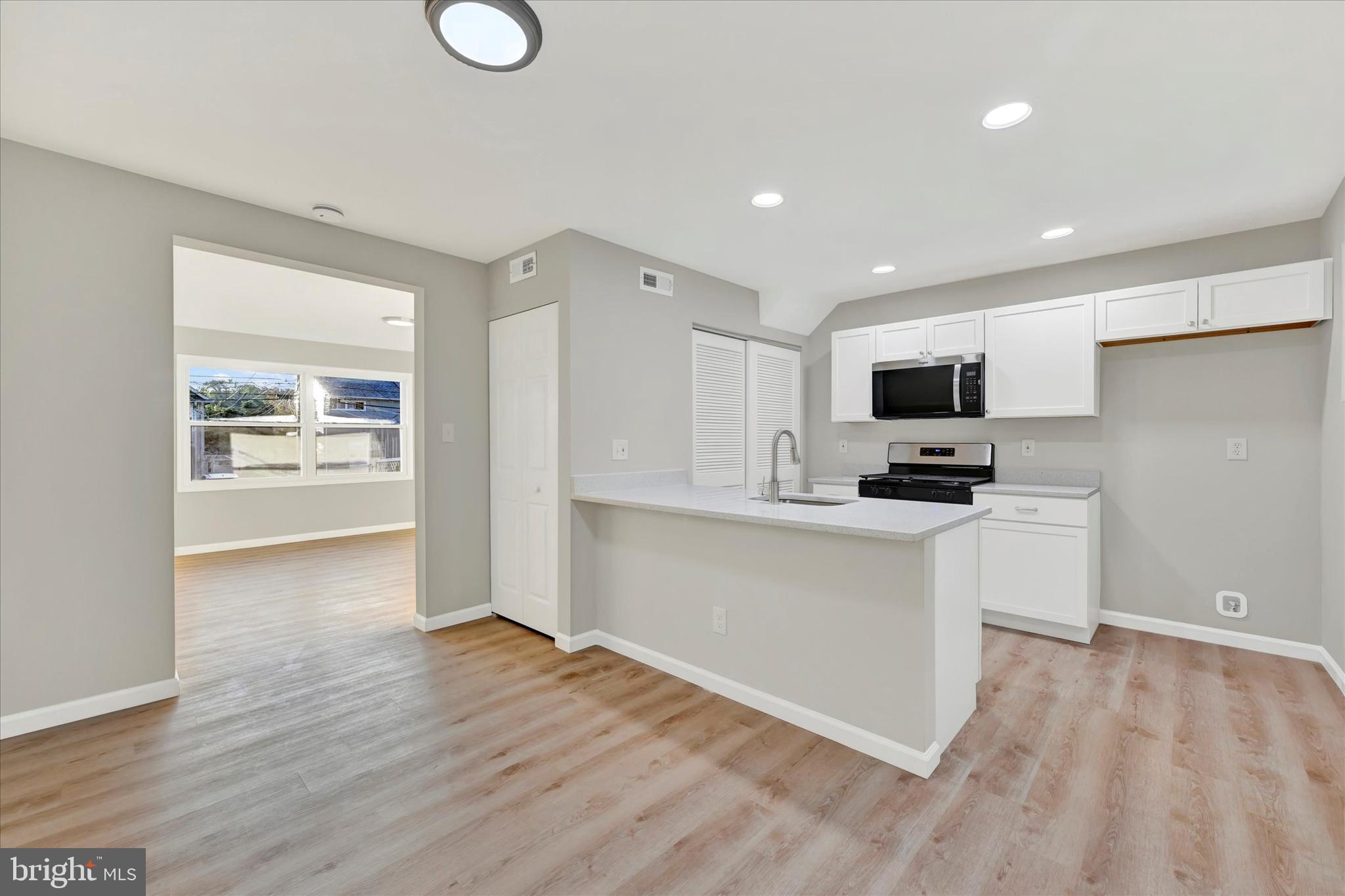 12106 Bluhill Road Silver Spring, MD 20902 - Photo 6 of 16 a kitchen with white cabinets and appliances