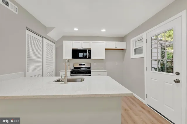 a kitchen with stainless steel appliances a sink stove and refrigerator