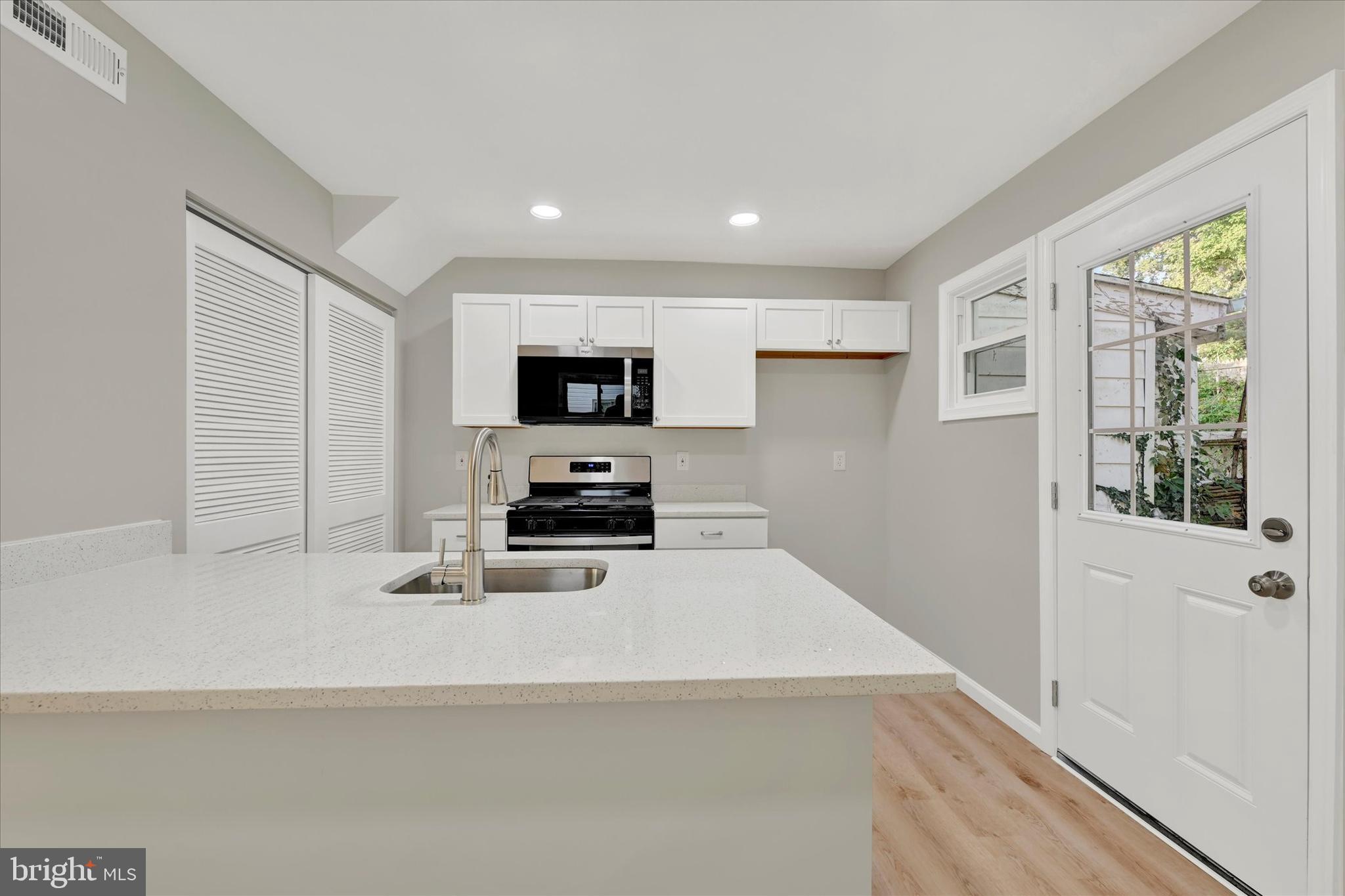 12106 Bluhill Road Silver Spring, MD 20902 - Photo 7 of 16 a kitchen with sink a microwave and cabinets