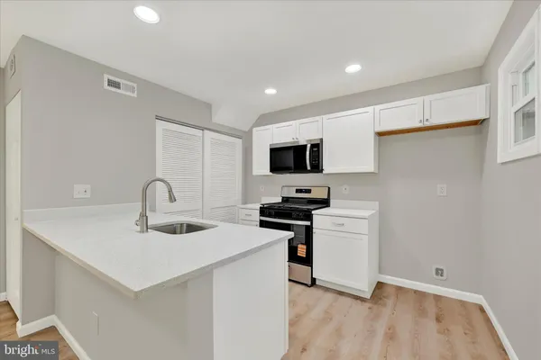 a kitchen with a sink appliances and cabinets