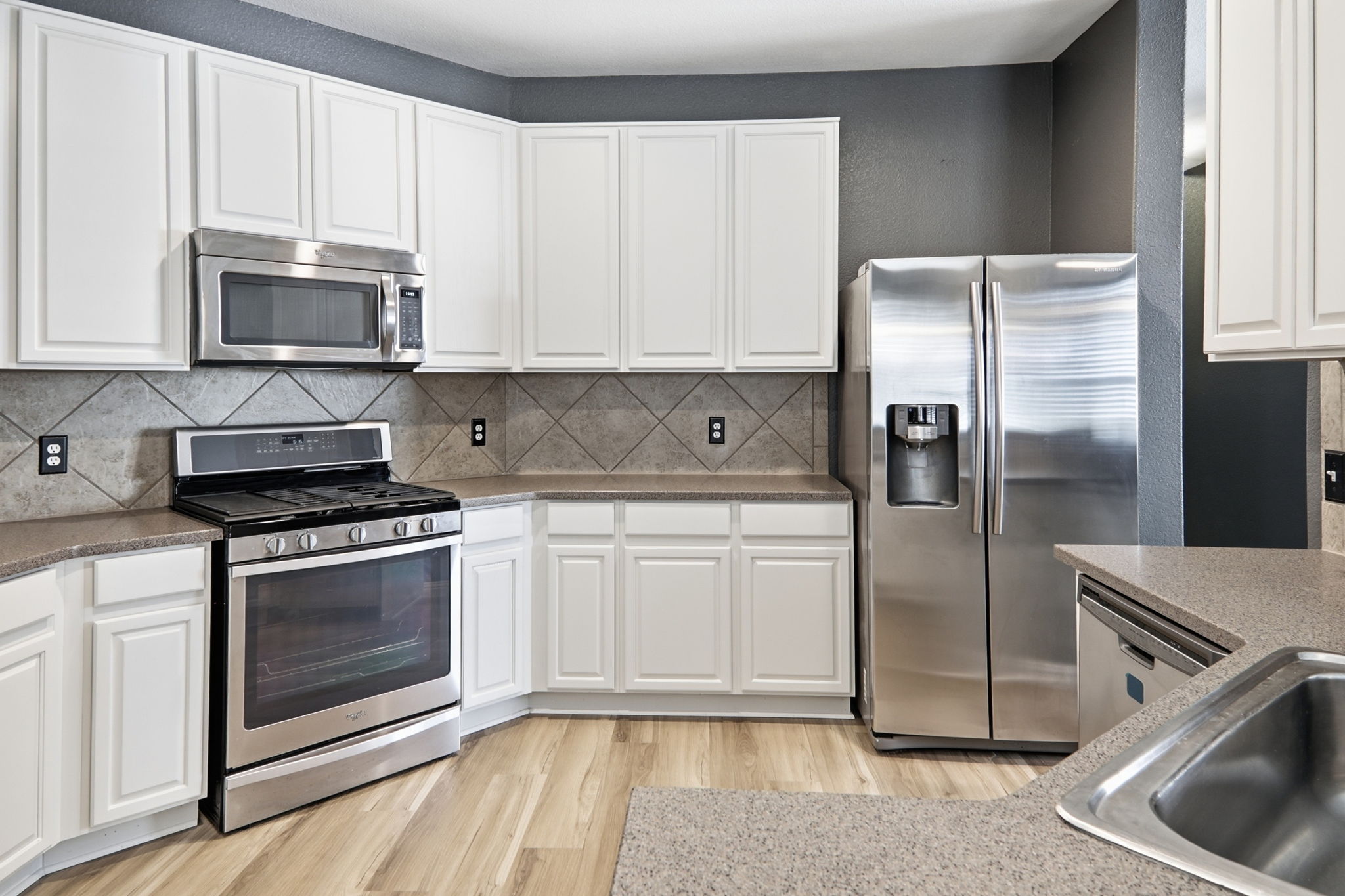 2157 Paradise Ridge Drive Round Rock, TX 78665 - Photo 10 of 34 a kitchen with white cabinets and stainless steel appliances
