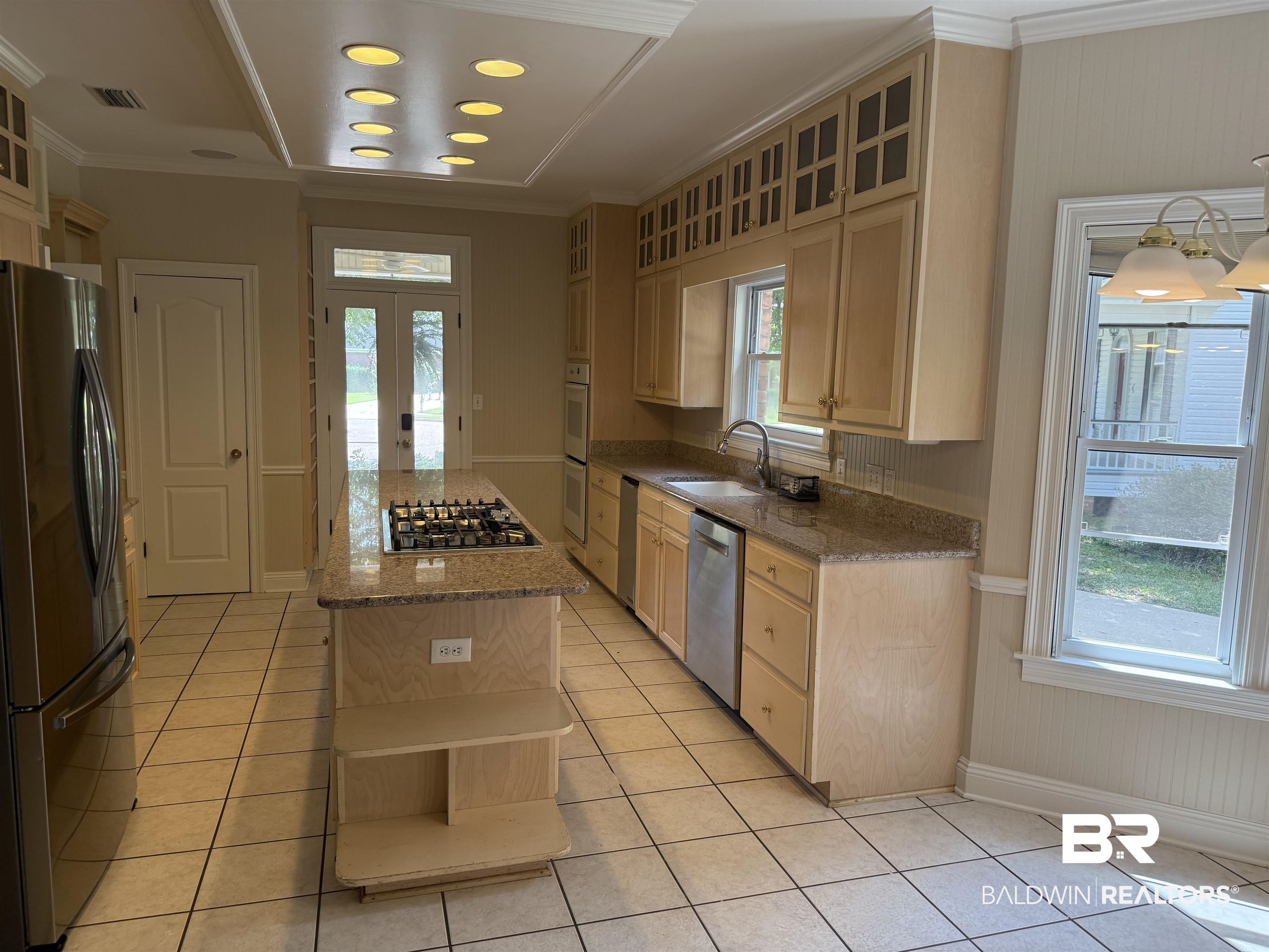 508 Barbara Court Daphne, AL 36526 - Photo 3 of 16 Kitchen featuring stainless steel appliances, open shelves, light brown cabinetry, light tile patterned floors, and crown molding