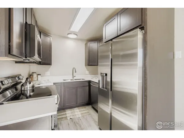 a kitchen with kitchen island granite countertop a sink stove and refrigerator