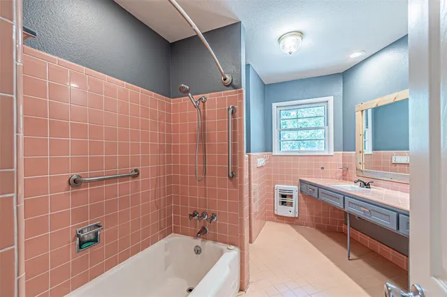a bathroom with a tub sink and mirror