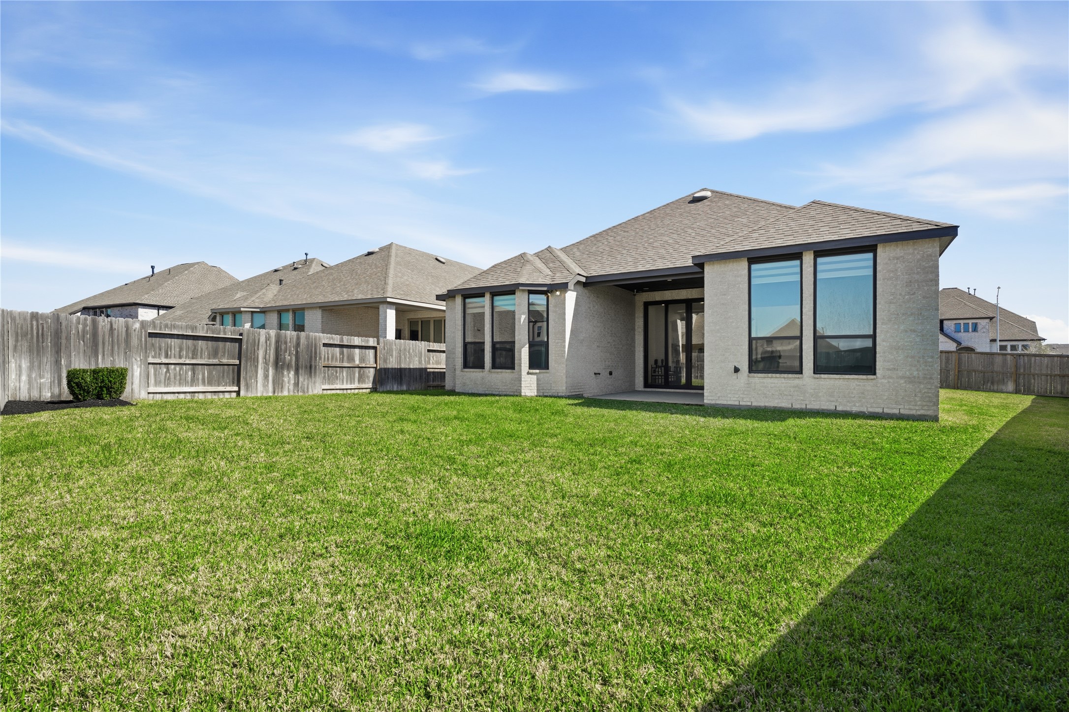 416 Bartlett Street Webster, TX 77598 - Photo 42 of 49 Fully fenced backyard with green lawn and covered patio access