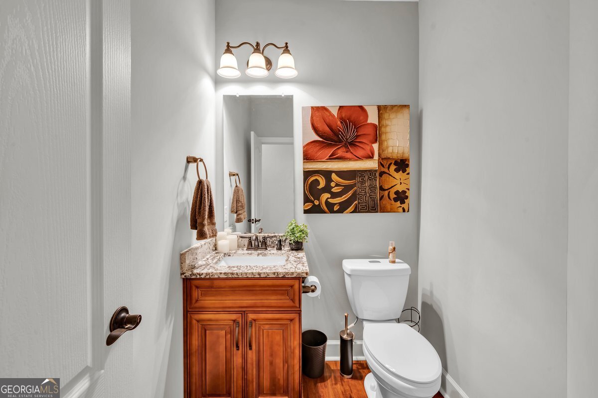 2594 Lassiter Road Forsyth, GA 31029 - Photo 11 of 28 a bathroom with a toilet a sink and a mirror
