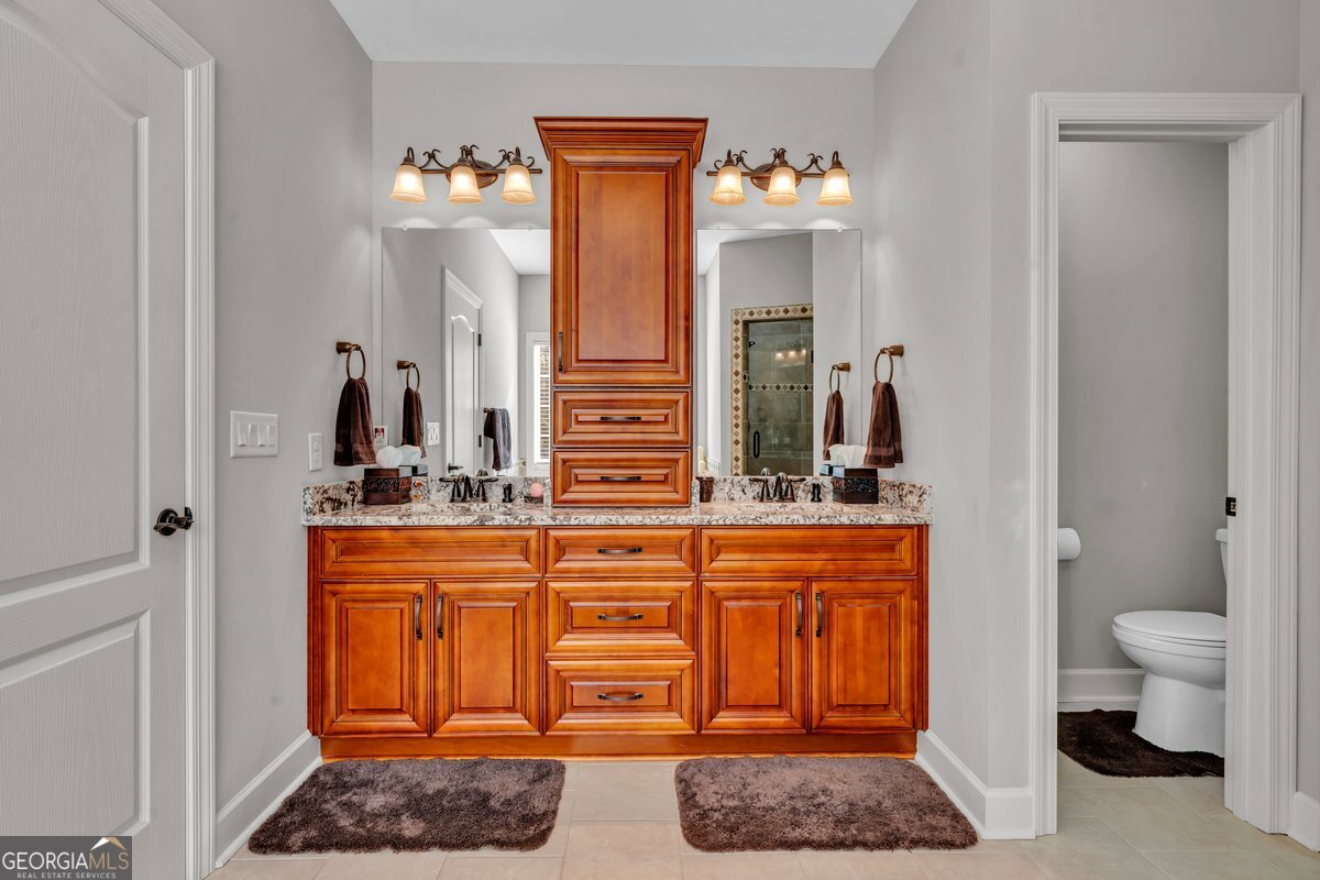 2594 Lassiter Road Forsyth, GA 31029 - Photo 15 of 28 a spacious bathroom with a granite countertop sink and a mirror