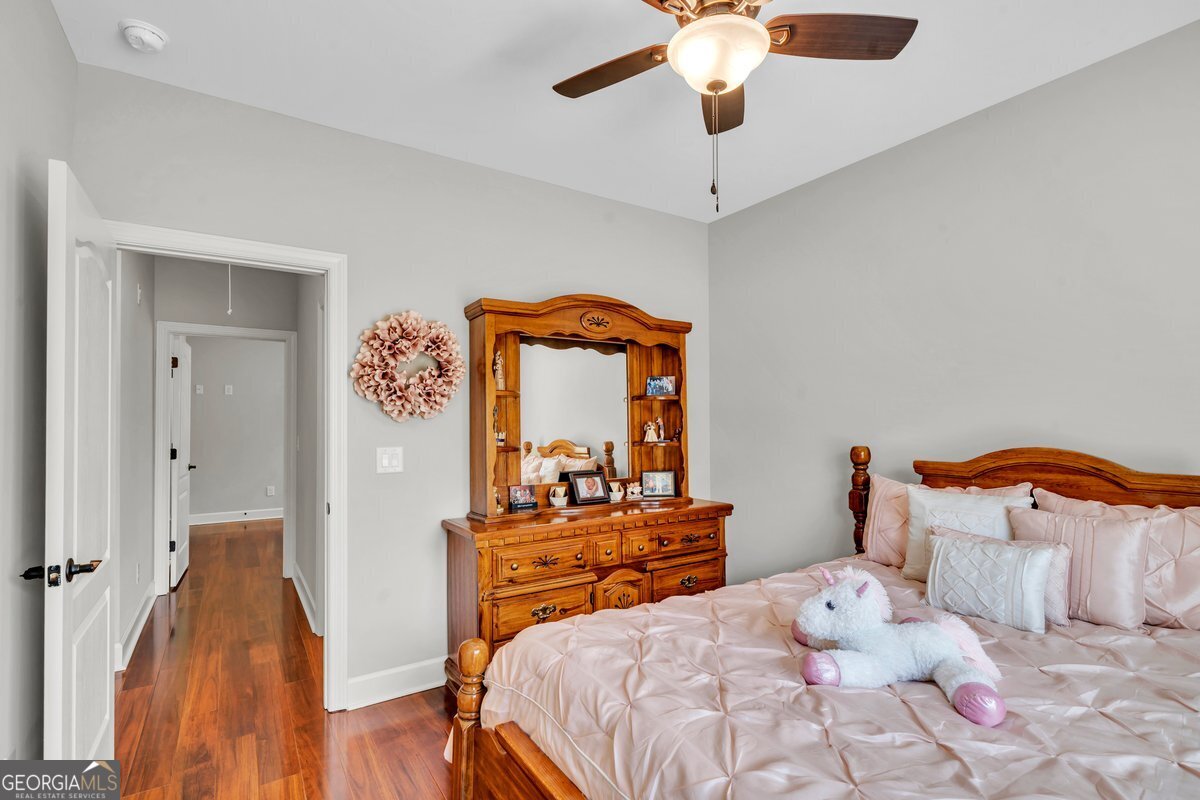 2594 Lassiter Road Forsyth, GA 31029 - Photo 19 of 28 a bedroom with a bed and a chandelier