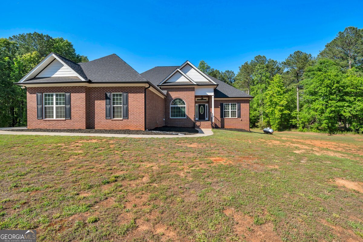 2594 Lassiter Road Forsyth, GA 31029 - Photo 2 of 28 a front view of a house with a garden
