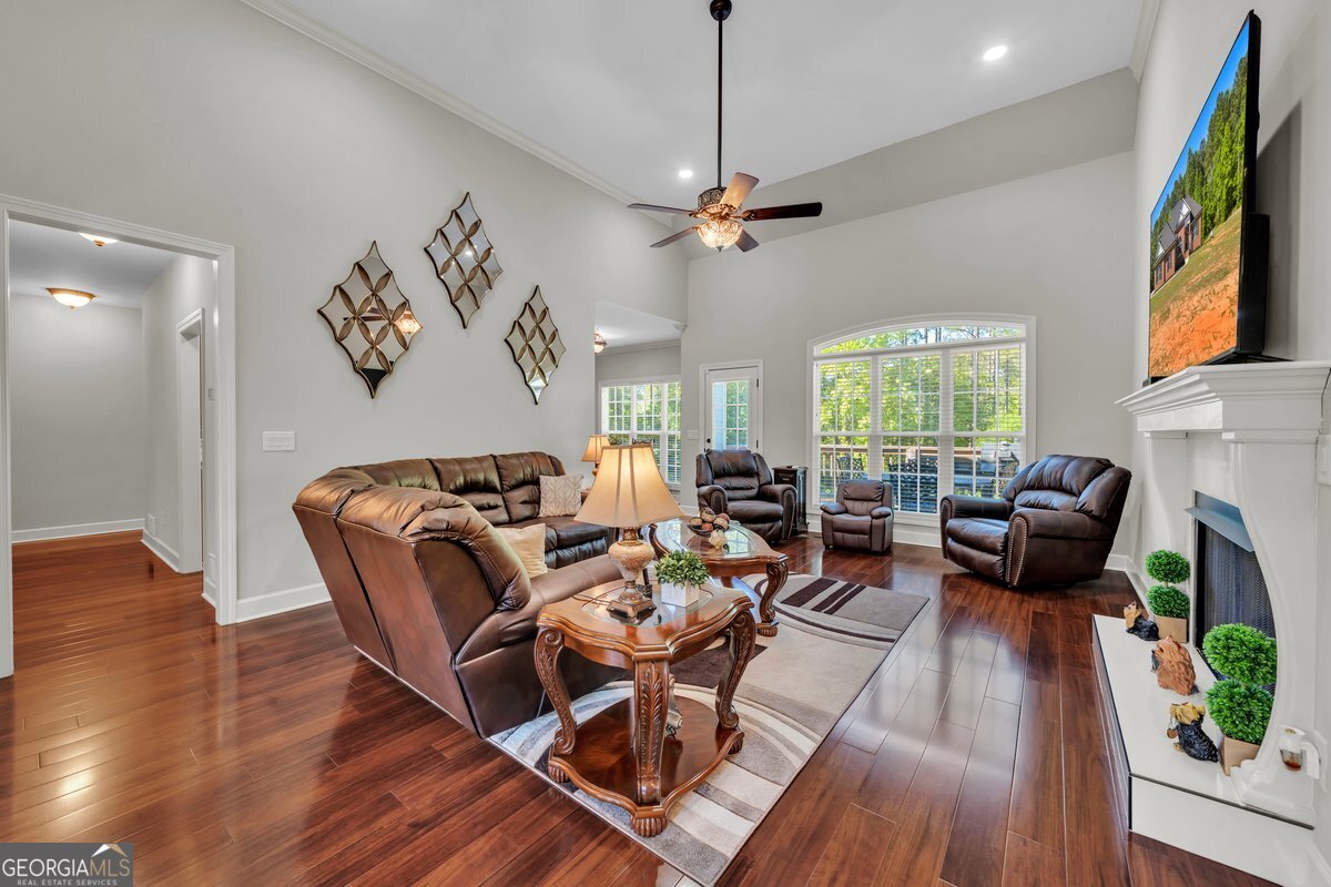 2594 Lassiter Road Forsyth, GA 31029 - Photo 4 of 28 a living room with furniture a fireplace and a flat screen tv
