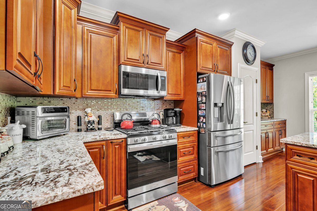 2594 Lassiter Road Forsyth, GA 31029 - Photo 6 of 28 a kitchen with stainless steel appliances granite countertop a refrigerator stove and sink