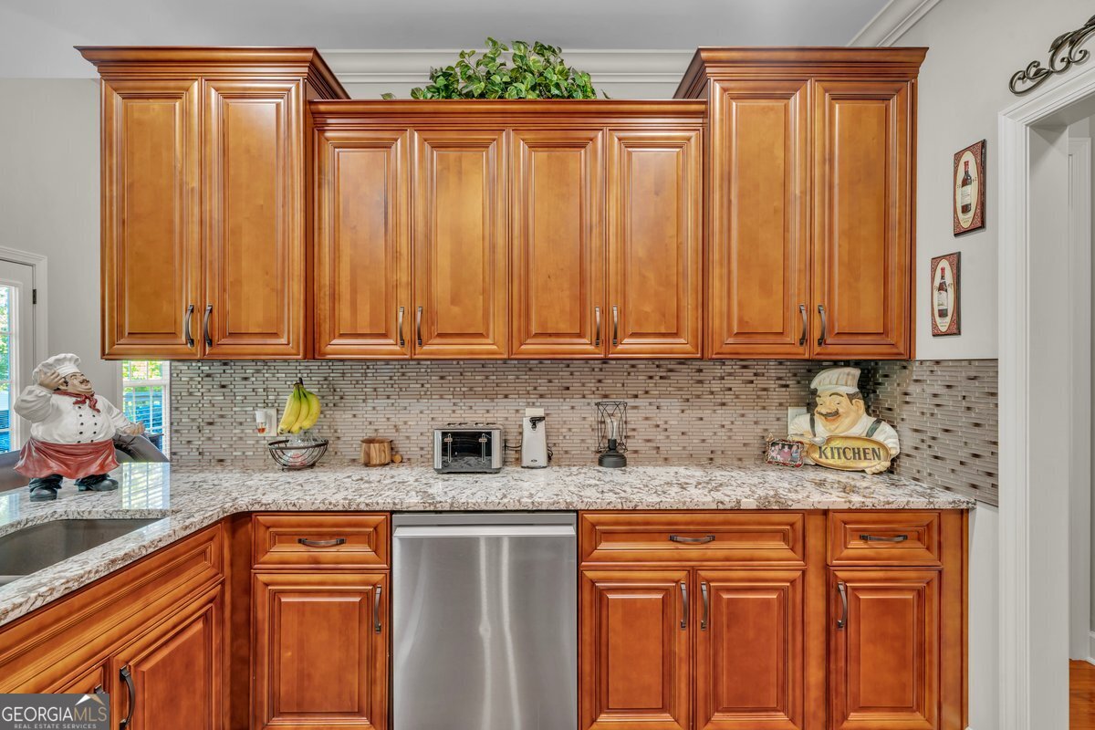 2594 Lassiter Road Forsyth, GA 31029 - Photo 9 of 28 a kitchen with stainless steel appliances granite countertop wooden cabinets a sink and dishwasher
