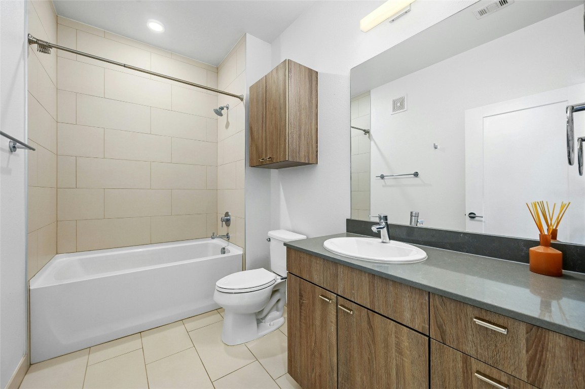 4361 South Congress Avenue, Unit 129 Austin, TX 78745 - Photo 19 of 25 a bathroom with a granite countertop sink a toilet and bathtub