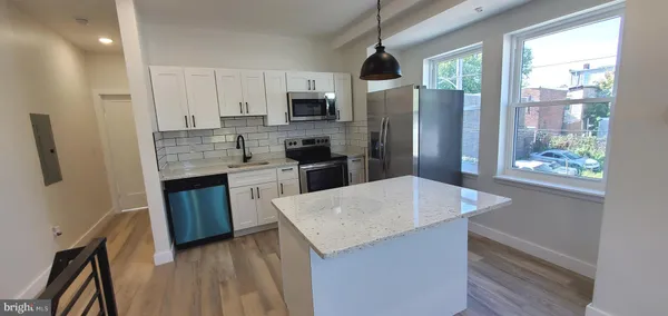 a kitchen with stainless steel appliances granite countertop a refrigerator a stove top oven a sink and dishwasher