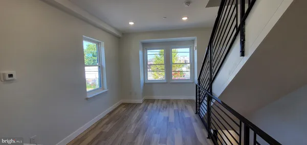 a view of a hallway with wooden floor and staircase