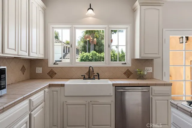 a kitchen with a sink a window and cabinets
