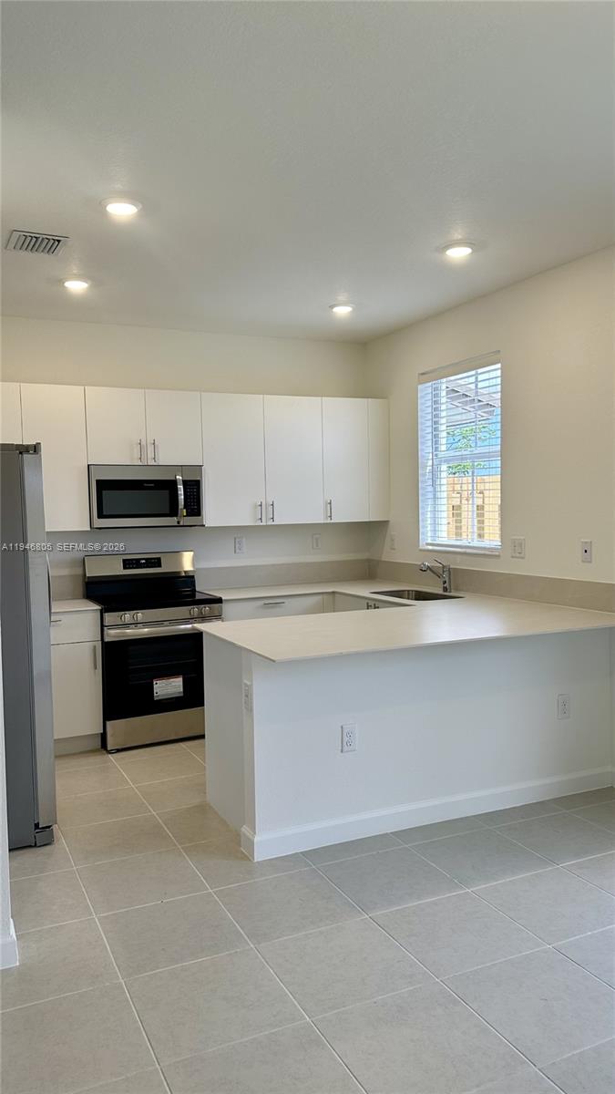 2713 Southeast 26th Road Homestead, FL 33035 - Photo 6 of 27 a kitchen with granite countertop a stove sink and cabinets