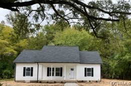 a front view of a house with a tree