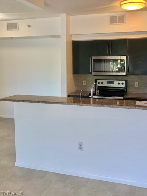 1210 Reserve Way, Unit 9203 Naples, FL 34105 - Photo 3 of 18 a bathroom with a sink and a microwave