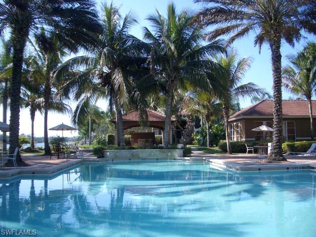 1210 Reserve Way, Unit 9203 Naples, FL 34105 - Photo 10 of 18 a palm tree sitting in front of a house with a fountain