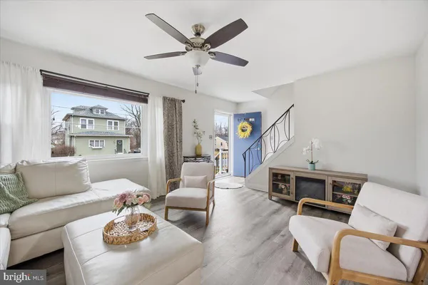 a living room with furniture kitchen view and a window