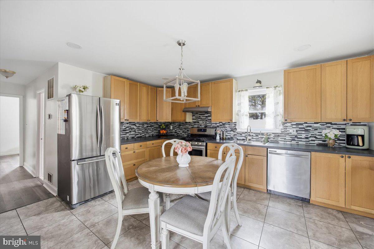 35 Rosedale Avenue Ewing, NJ 08638 - Photo 16 of 35 a kitchen with granite countertop a refrigerator a stove a sink a dining table and chairs