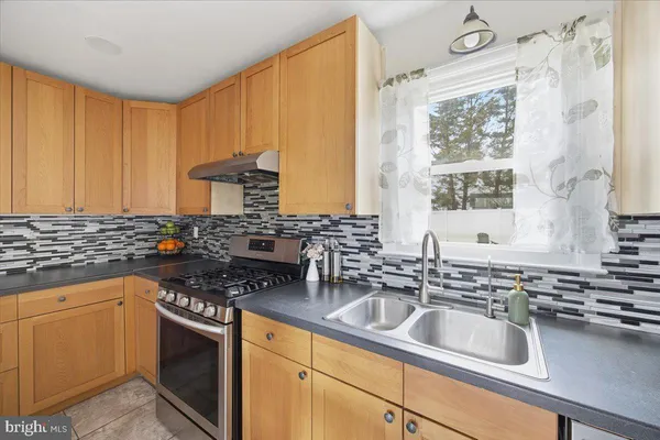 a kitchen with stainless steel appliances a sink stove and cabinets