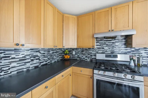 a kitchen with granite countertop a stove sink and cabinets
