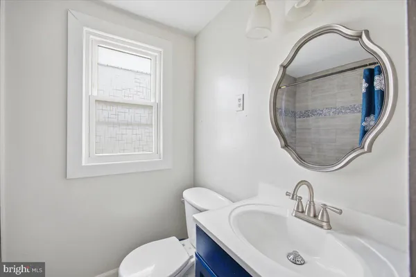 a bathroom with a sink mirror and toilet