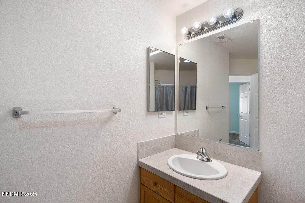 1706 River Gorge Court Reno, NV 89521 - Photo 21 of 40 a bathroom with a sink and a mirror