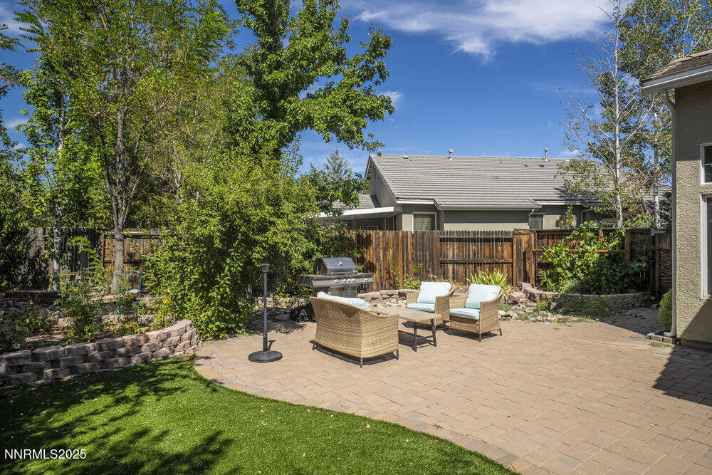 1706 River Gorge Court Reno, NV 89521 - Photo 33 of 40 a view of a patio with table and chairs potted plants and large tree