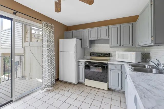 a kitchen with a refrigerator sink and cabinets