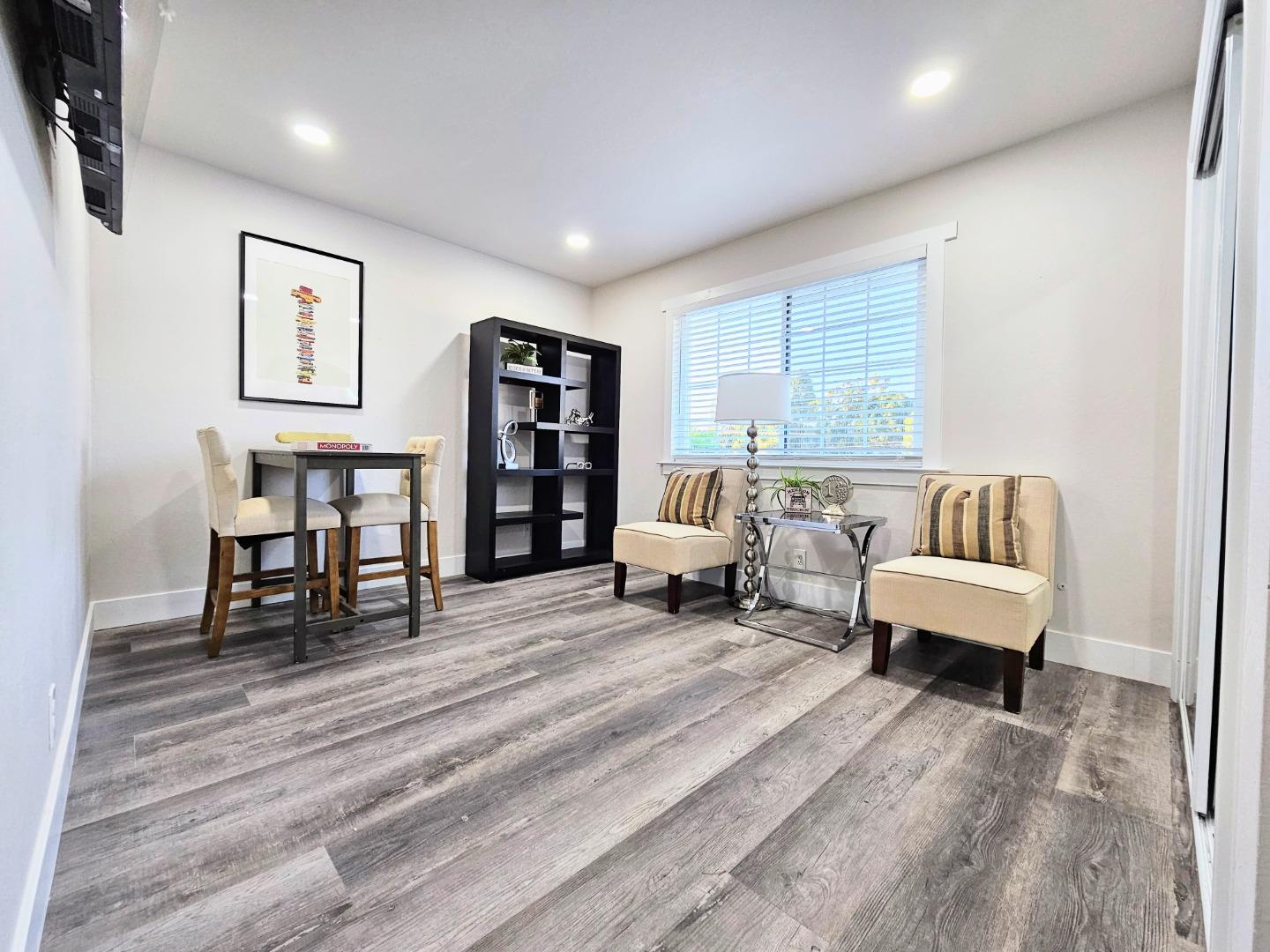 17675 Laurel Road Morgan Hill, CA 95037 - Photo 29 of 49 a spacious bedroom with a bed a couch and a bookshelf with wooden floor
