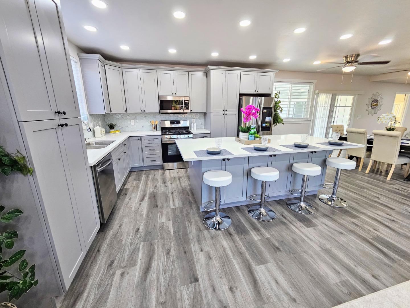 17675 Laurel Road Morgan Hill, CA 95037 - Photo 6 of 49 a kitchen with a table chairs wooden floors and a view of living room