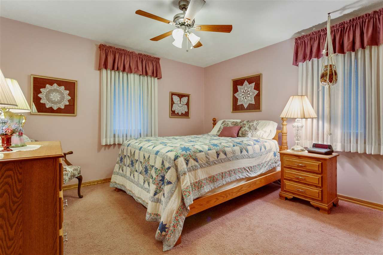 6871 Spring Brook Road Rockford, IL 61114 - Photo 12 of 24 a bedroom with a bed and a chandelier