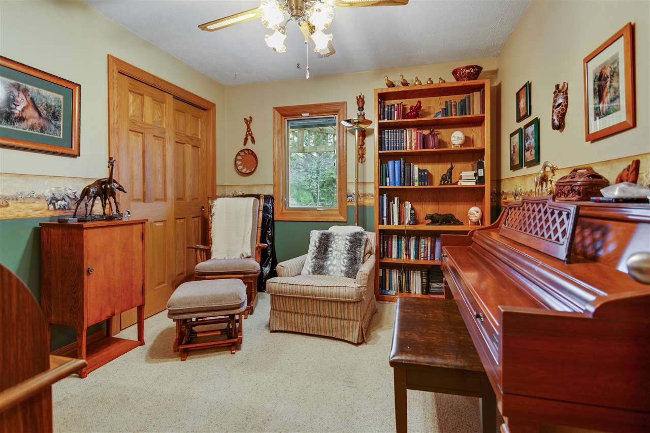 6871 Spring Brook Road Rockford, IL 61114 - Photo 14 of 24 a living room with furniture a bookshelf and a bookshelf