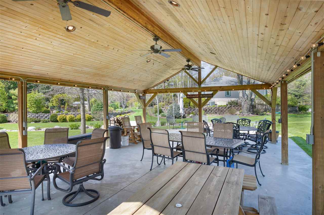 6871 Spring Brook Road Rockford, IL 61114 - Photo 24 of 24 a view of a patio with chairs and table under an umbrella