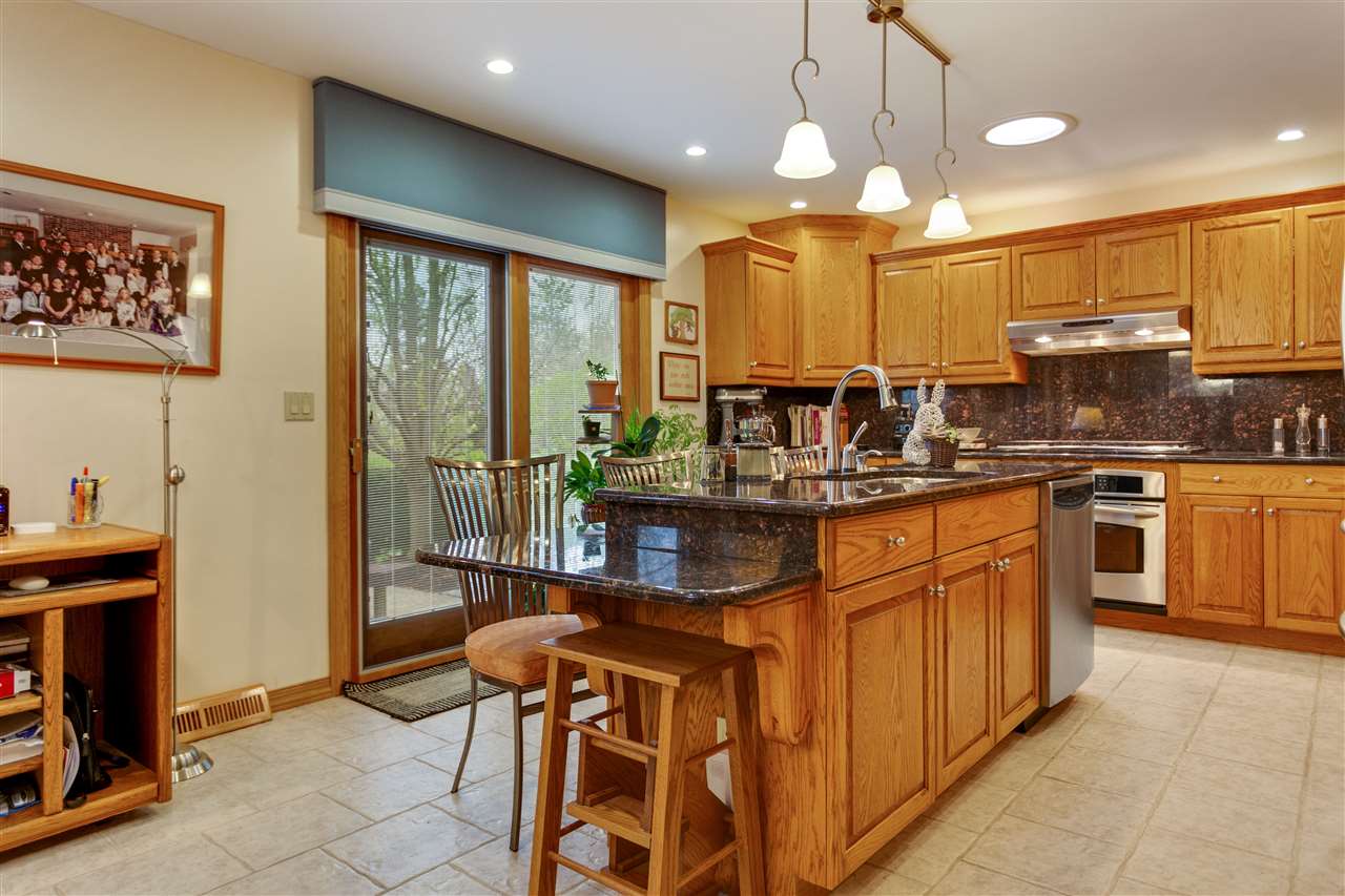 6871 Spring Brook Road Rockford, IL 61114 - Photo 4 of 24 a kitchen with stainless steel appliances granite countertop a stove a sink and a refrigerator