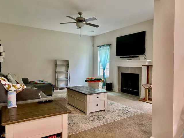 a living room with furniture a flat screen tv and a fireplace