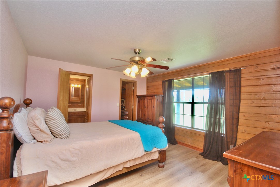 2725 Old Lehmann Road Seguin, TX 78155 - Photo 16 of 47 a bedroom with a large bed and a chandelier
