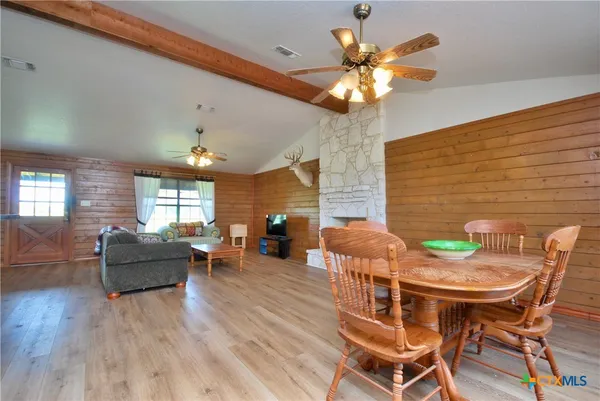 a kitchen with stainless steel appliances granite countertop a refrigerator a sink dishwasher a stove and white cabinets with wooden floor