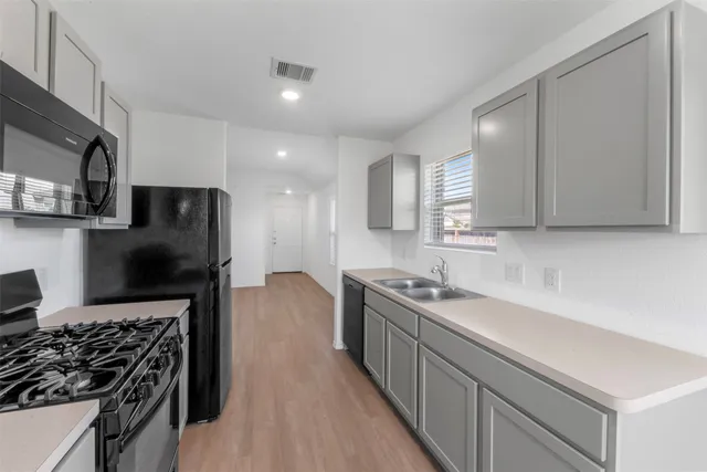 a kitchen with stainless steel appliances a sink stove and cabinets