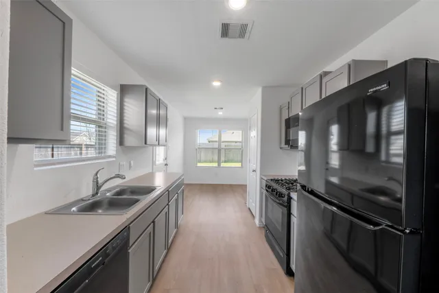 a kitchen with a sink stove and refrigerator