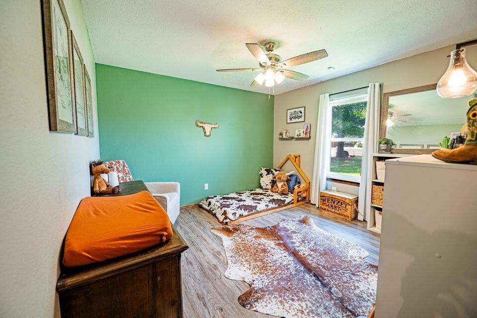 2914 Kermit Drive Plainview, TX 79072 - Photo 14 of 18 a bedroom with a bed and wooden floor