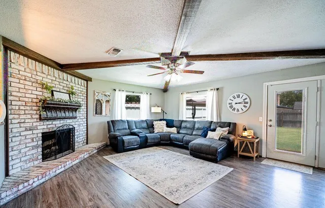a living room with furniture a fireplace and a flat screen tv