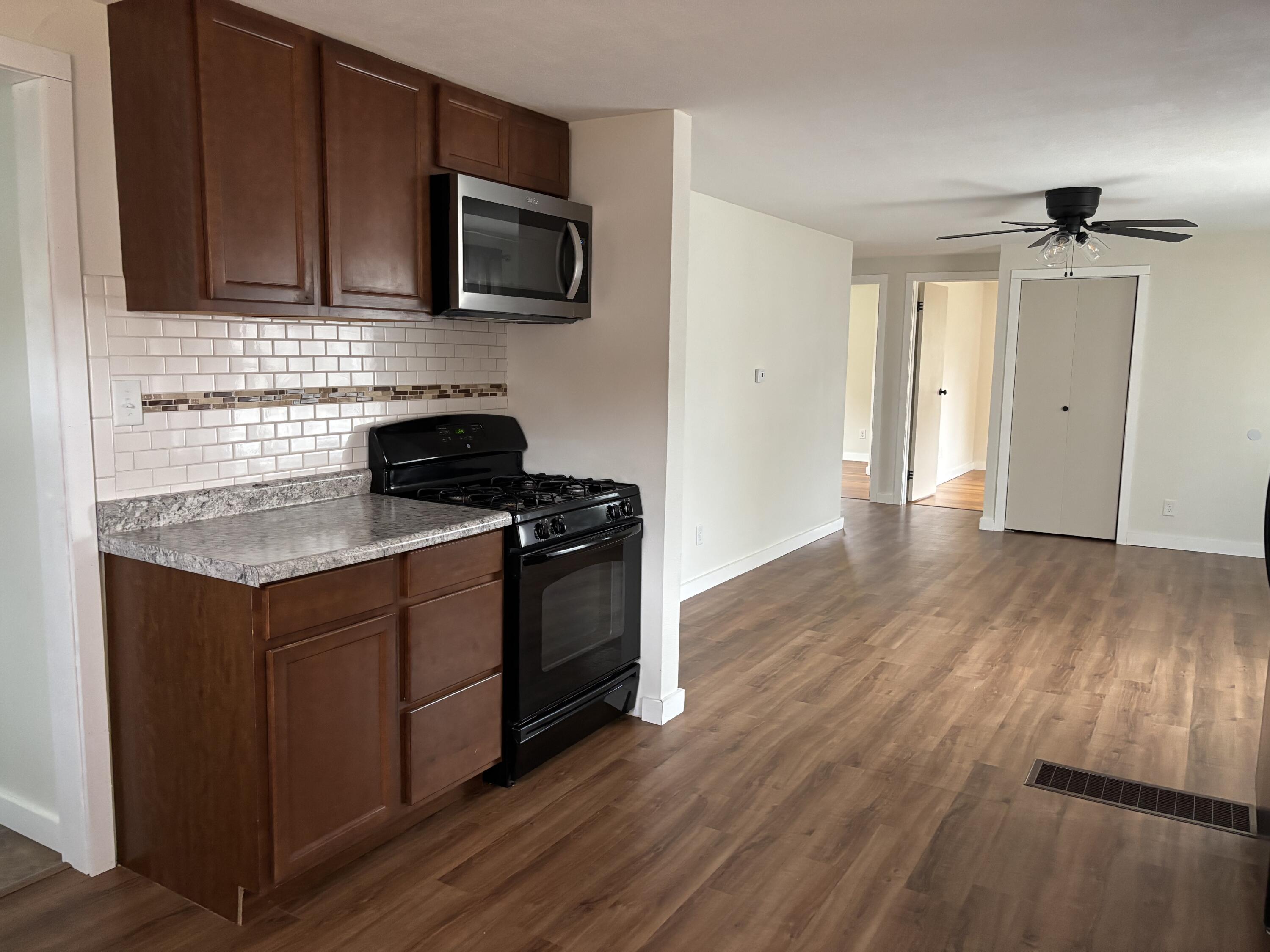 212 South Milton Street Rensselaer, IN 47978 - Photo 2 of 14 a kitchen with granite countertop wooden cabinets and a stove top oven