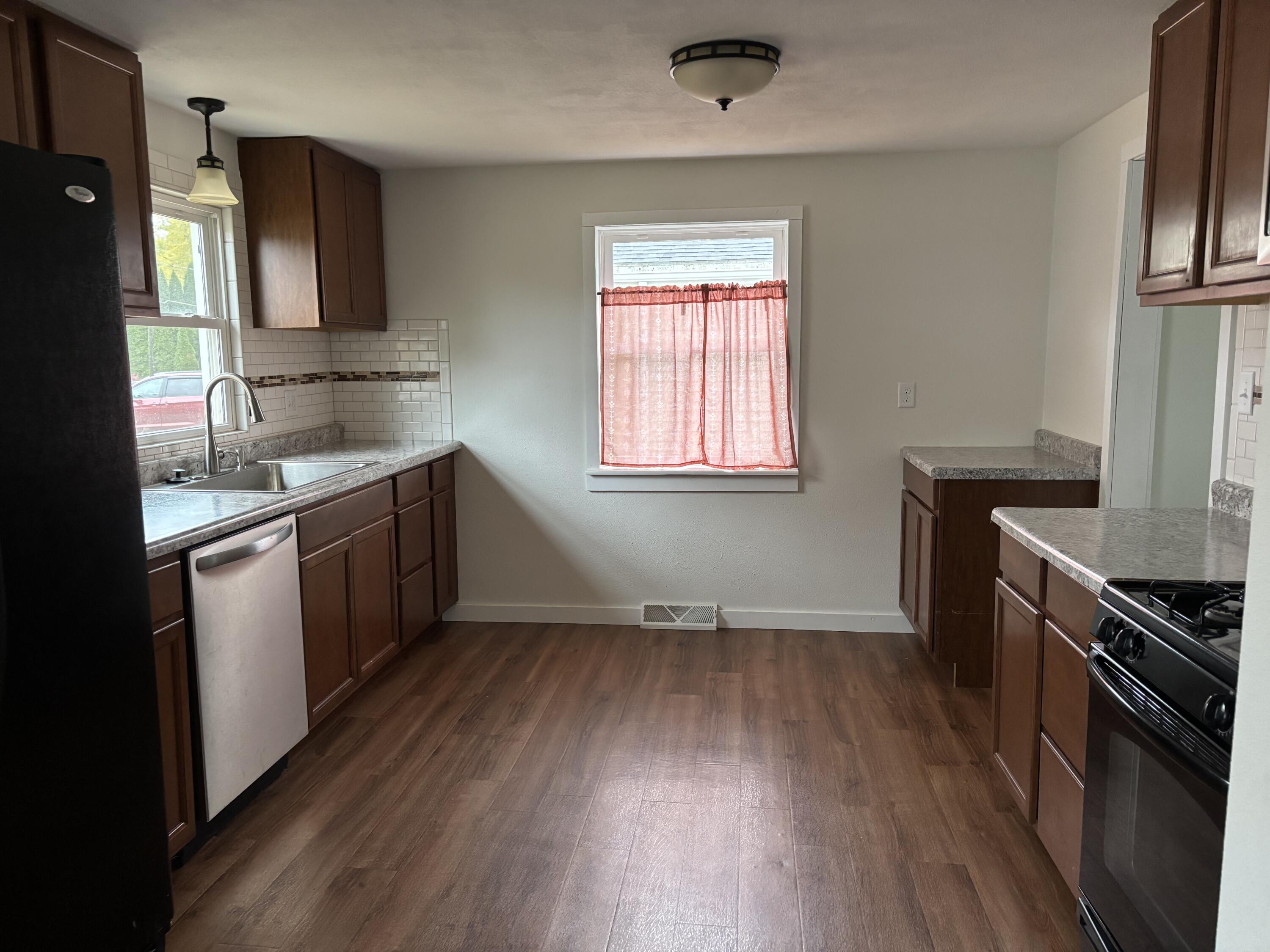 212 South Milton Street Rensselaer, IN 47978 - Photo 4 of 14 a kitchen with a sink wooden floor and stainless steel appliances