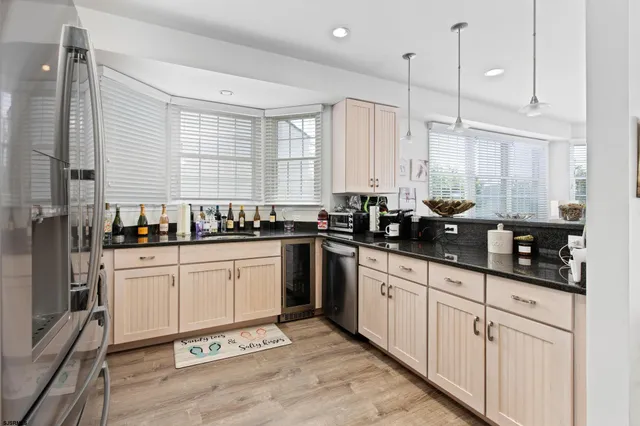 a kitchen with stainless steel appliances granite countertop a sink a stove and white cabinets